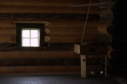window inside an old wooden hut, millstone