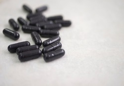 many black pills on grey white background