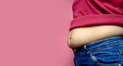 Overweight fat woman isolated on a pink background in Studio, Weight losing, obesity, cellulite, health care concept. copy space background for text