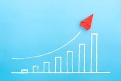Red paper plane with growing a sketch graph on blue background, Growth and successful concept.
