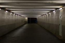 Underground pedestrian crossing. A long concrete tunnel with lanterns in the city underground. Underpass. underground passage