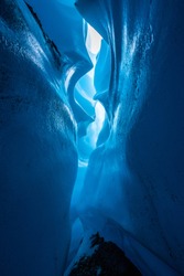 From inside the depths of a narrow winding canyon cut through the ice of hte Matanuska Glacier. Lit to show detail in the ice with rock below