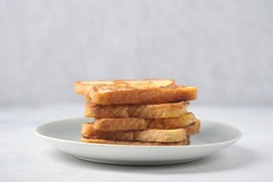 White bread toasts on a plate. Light background. Close-up. Free space for text.