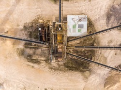 Vertically taken aerial photograph with the view of a large processing machine when used in a sand quarry, to divide the dredged material into different fractions, abstract aerial view, drone shot