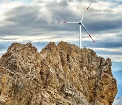 Fake composite of a wind turbine behind the summit of Zugspitze, the highest mountain in Germany