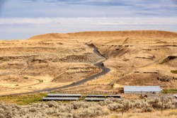 A farm in eastern Washington and a winding and curvey road in  high desert country