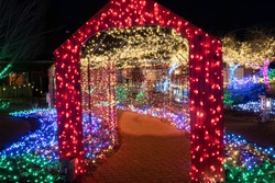 A Christmas lighting display, a brightly illuminated tunnel of colorful lights