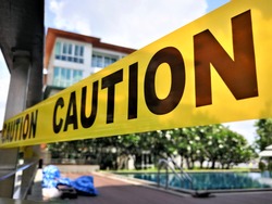 Caution tape and blurred law enforcement and forensic background