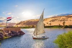 Egiptian flag and sailboat on river Nile in Aswan