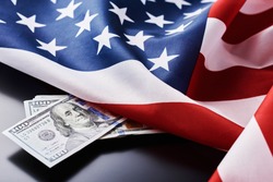 USA national flag and currency usd money banknotes on dark background. Business and finance concept