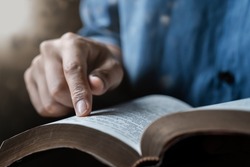 Close-up of a man reading the Bible Spiritual concepts by studying the Holy Scriptures together.