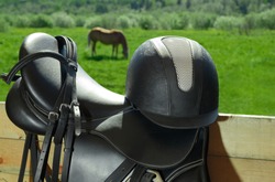 The bridle, the horse saddle and the riding helmet are in outdoors.