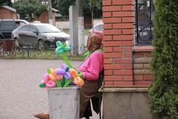 Grandmother in bright cloth selling balloons on the  street, Ukraine