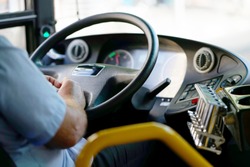 Hands of driver in a modern bus by driving.Concept - close-up of bus driver steering wheel and driving passenger bus