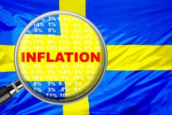 Magnifying glass focused on the word inflation on Sweden flag background. Hike interest rate. Inflation income crisis. Inflation, tax, cash flow and another financial concept in Sweden