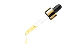 Yellow essential serum oil dripping from gold dropper  isolated on white background. Clipping path.