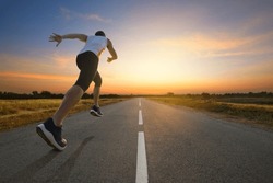 A man running on country road with sun dawn sky background.
