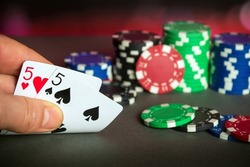Poker cards with one pairs combination. Close up of gambler hand takes playing cards in casino