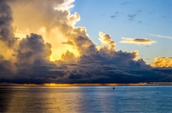 The sun is behind the clouds. Cloudy sky over water. Dark cloudy sky sunlight. Dark sky clouds landscape