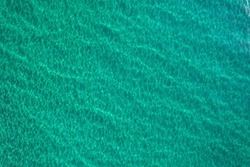 Aerial fly over looking down at pristine clear turquoise water in the Mediterranean Sea