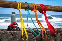 Variety of different color and weight resistance bands for outdoor seaside workout