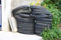 Old motorcycle tires and bicycle tires stacked,