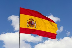 Spain flag isolated on the blue sky with clipping path. close up waving flag of Spain. flag symbols of Spain.