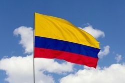 Colombia flag isolated on the blue sky with clipping path. close up waving flag of Colombia. flag symbols of Colombia.