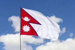 Nepal flag isolated on the blue sky with clipping path. close up waving flag of Nepal. flag symbols of Nepal.
