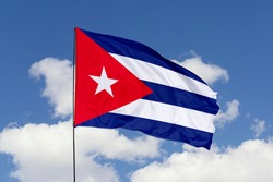 Cuba flag isolated on the blue sky with clipping path. close up waving flag of Cuba. flag symbols of Cuba.