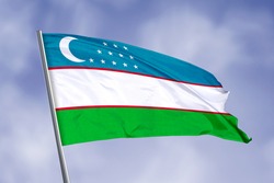 Uzbekistan flag isolated on sky background. close up waving flag of Uzbekistan. flag symbols of Uzbekistan.