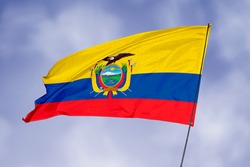 Ecuador flag isolated on sky background. National symbol of Ecuador. Close up waving flag with clipping path.