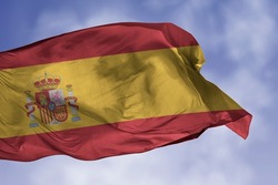 Spain flag isolated on the blue sky with clipping path. close up waving flag of Spain. flag symbols of Spanish.