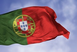 Portugal flag isolated on the blue sky with clipping path. close up waving flag of Portugal. flag symbols of Portuguese.