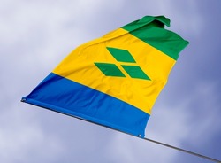 Saint Vincent's flag is isolated on a sky background. flag symbols of Saint Vincent. close up of a Saint Vincent flag waving in the wind.