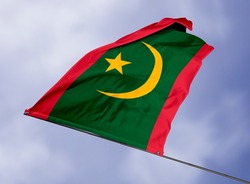Mauritania's flag is isolated on a sky background. flag symbols of Mauritania. close up of a Mauritanian flag waving in the wind.