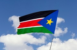 South Sudan flag is isolated on the blue sky with a clipping path. flag symbols of South Sudan.