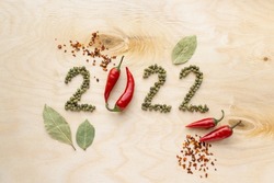 New year and christmas concept. Text 2022 made of pepper on wooden background, top view