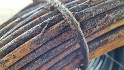 Close-up of rust wire coils in metal steel industrial yard or storage area, steel wire coils or wire rod for wires industry production, concrete usage and building construction 