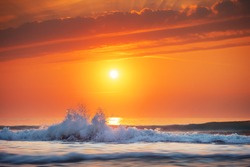 Golden sea sunrise and rolling wave on the shore