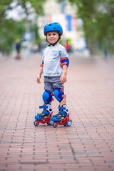 Little baby boy riding roller skates. Kid with helmet and protection on roller blades. Roller skating. Varna