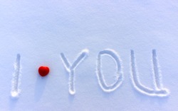 The simple innocent inscription written by hand I love you on a white clean snow with with place for writing. A declaration of love as a background on Valentine's Day. Red heart on snow