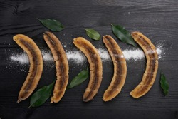 
Banana dessert with mint on a black background. Traditional Thai and Asian restaurant menu recipe, Horizontal photography with black background. Top view, flat, overhead.