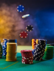 A beautiful composition - multi-colored chips. Levitation. Multicolored smoky background. Casino, online casino, night club. Gambling business, poker, risk, cash flows.