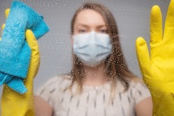Focusing on cleaning and cleaning. The girl maintains cleanliness, masked and with chemistry. Viruses and diseases, cleanliness.
