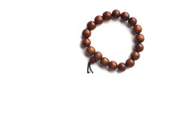 Wooden rosary beads bracelet isolated on white background. Dark brown. Copy space.