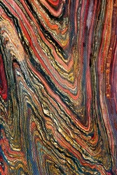 The colorful pattern of a cut and smooth polished tiger iron in a close-up view