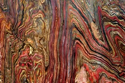The colorful pattern of a cut and smooth polished tiger iron in a close-up view
