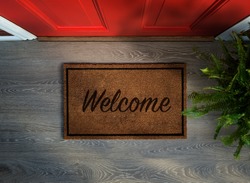 Overhead view of welcome mat outside inviting front door of house with potted fern plant