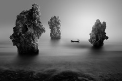 lonely fisherman on the stone beach, black and white photography